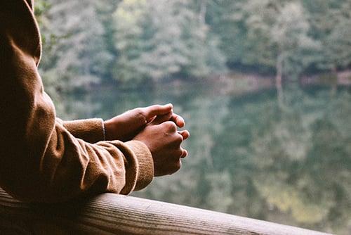 hands clasped on a railing viewing nature