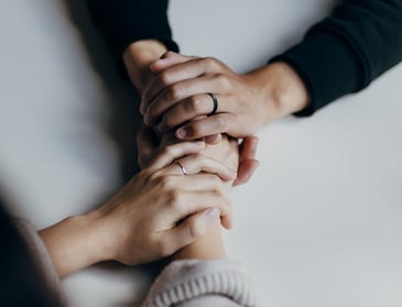 two hands holding each other to show support and comfort